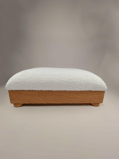 Earthly Cloud - msoth The Earthly Cloud rectangular footrest is an elegant and comfortable addition to any living space. It features a luxurious boucle upholstery in a soft, inviting cream color and a sturdy litEre wood frame supported by short, rounded legs. The frame has a natural finish, adding a touch of warmth and sophistication to any room. The footrest offers support and comfort for your feet, reducing fatigue and improving circulation. 